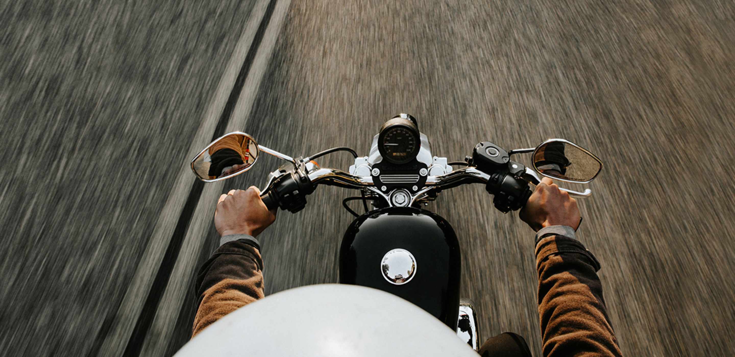 Motorcycle rider protected by AAA motorcycle insurance riding on a road.