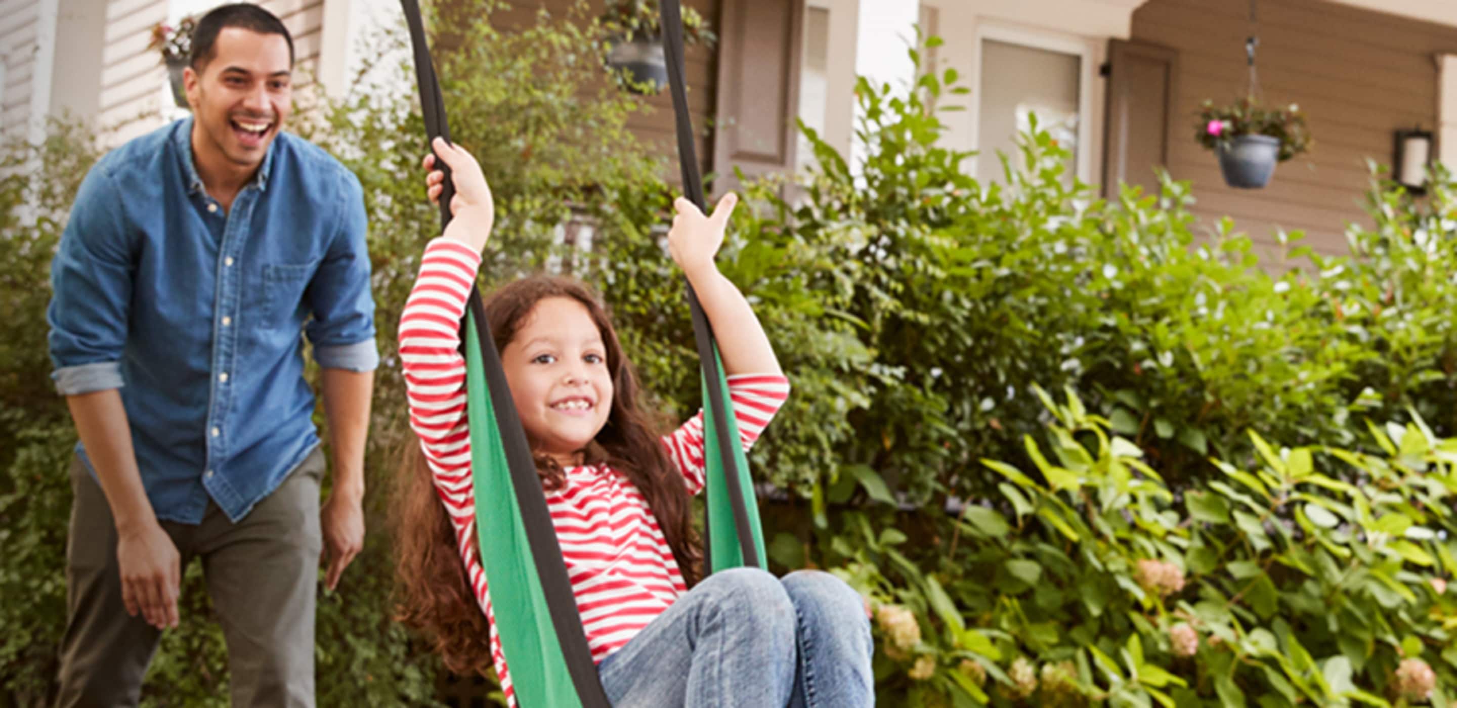 father and daughter swinging
