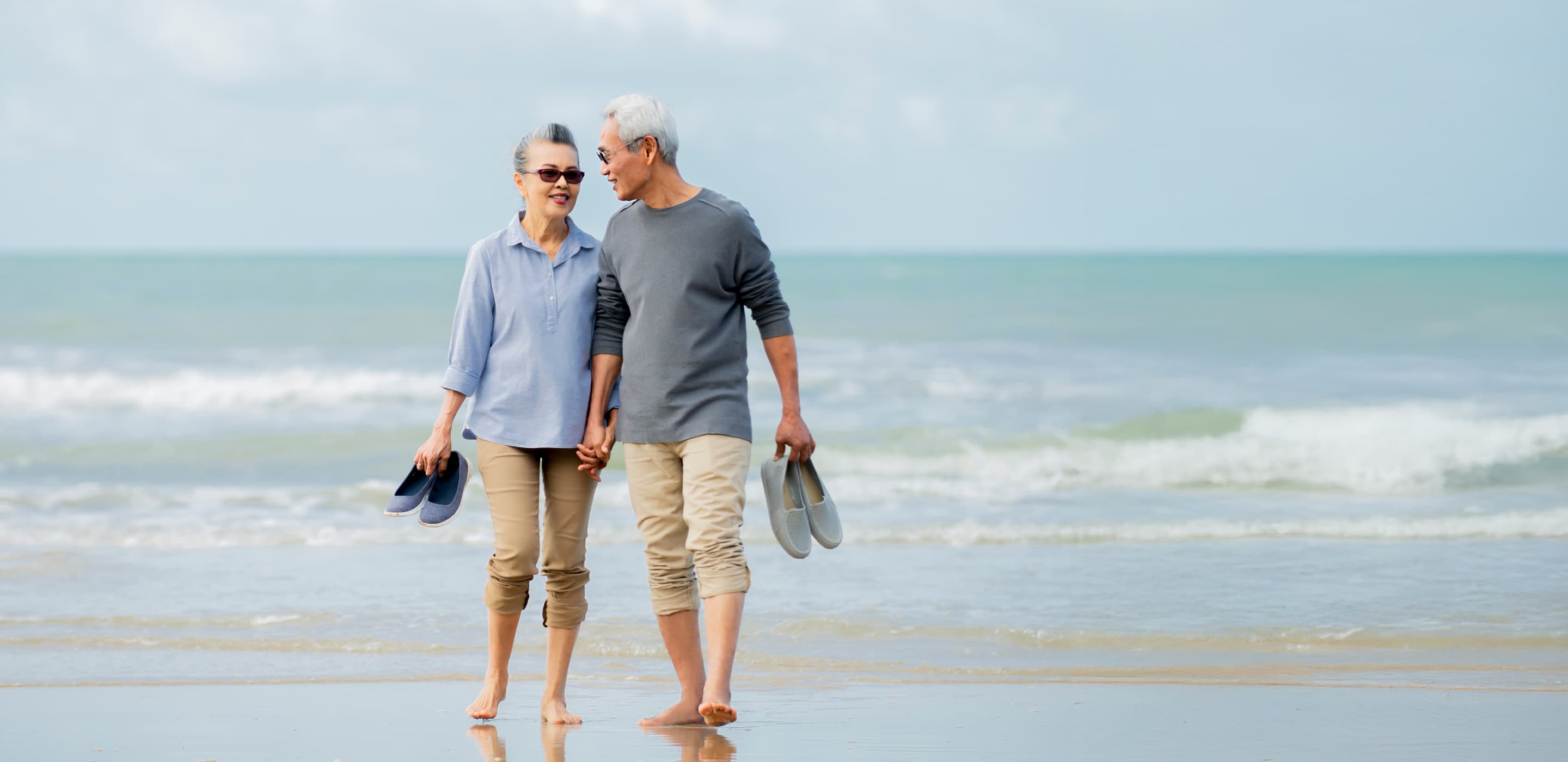 A couple with AAA whole life insurance walk on the beach