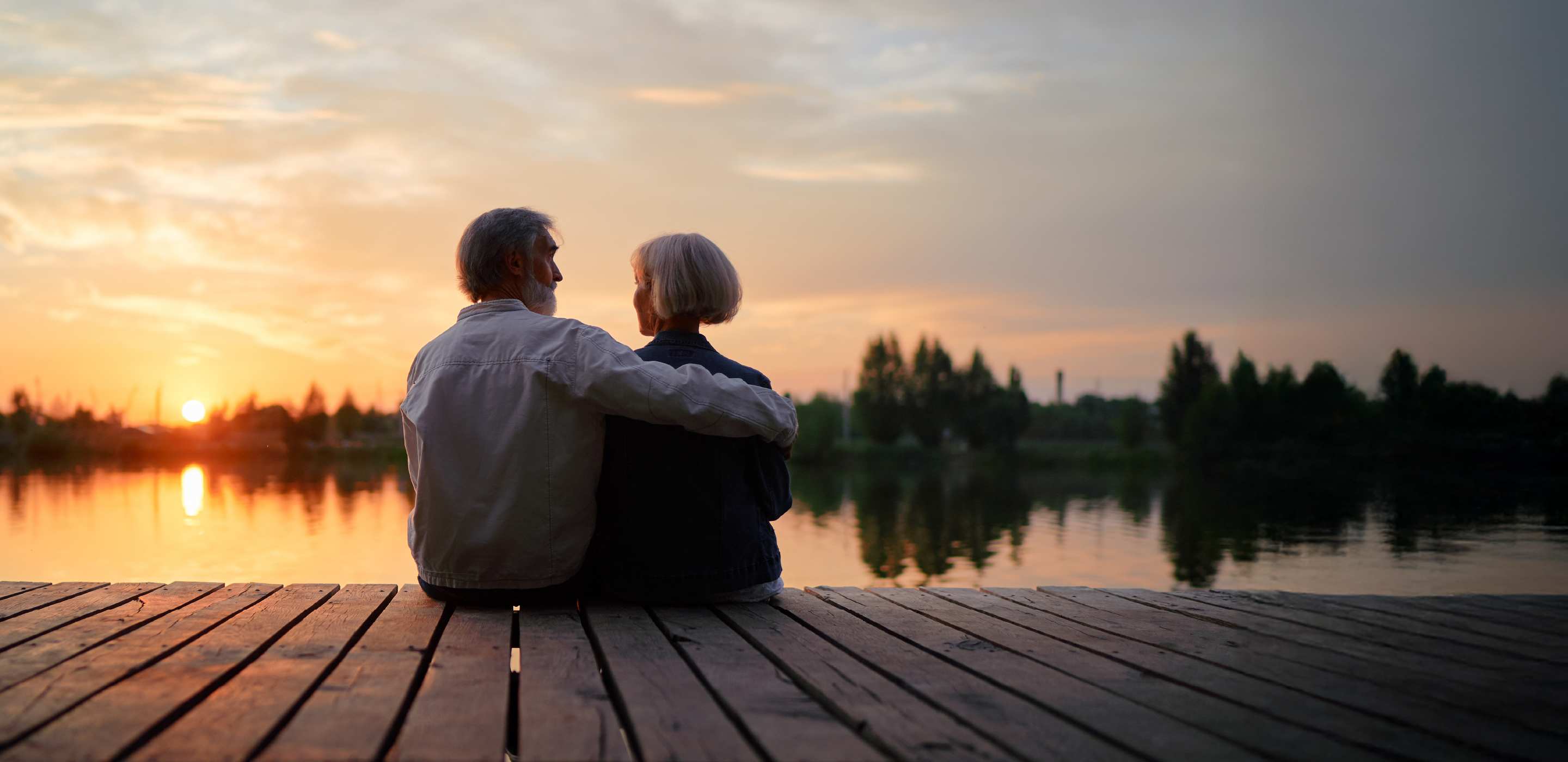 AAA Universal Life Insurance policyholders sit on a dock at sunset