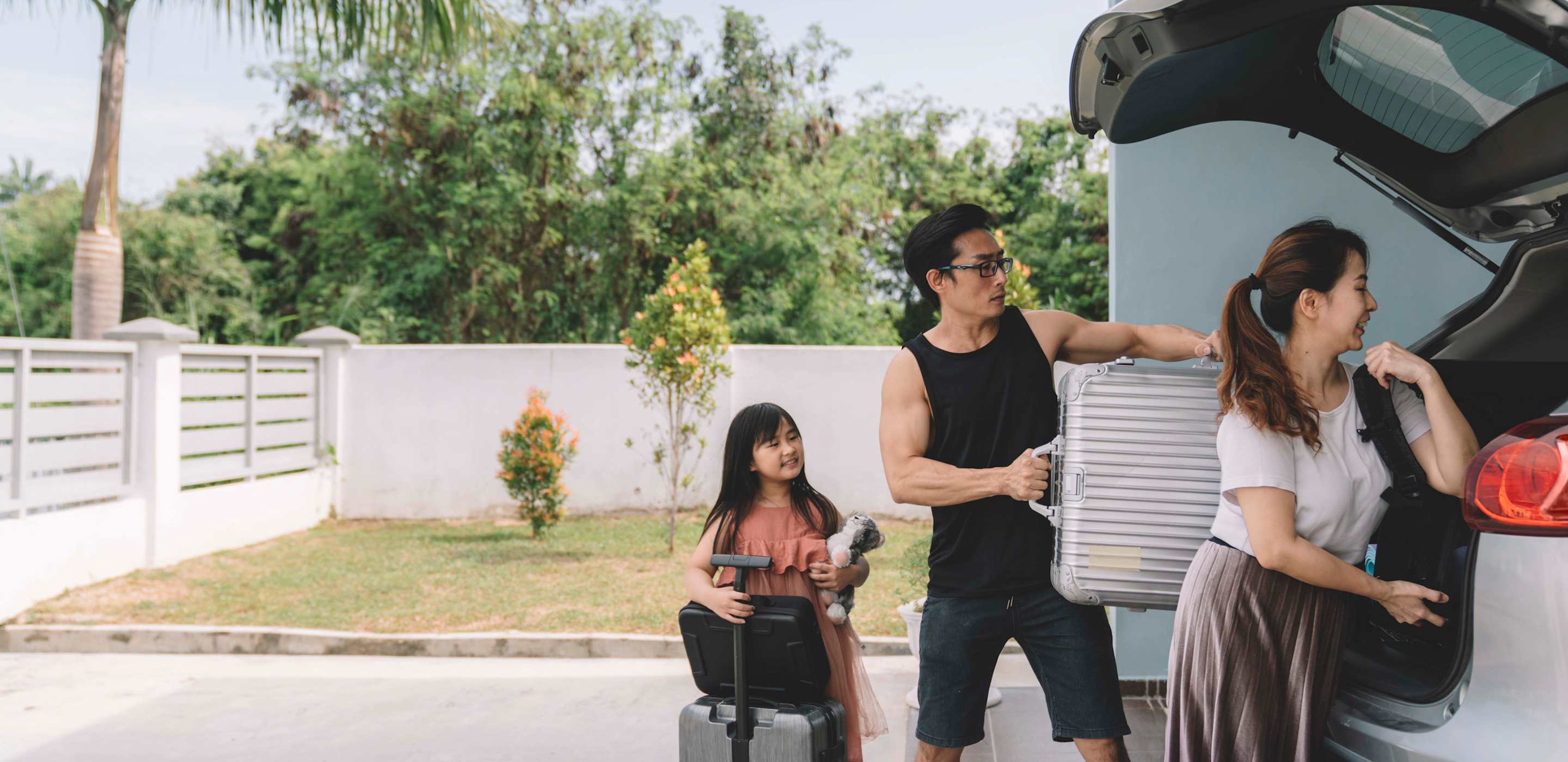 family loading suitcases in car
