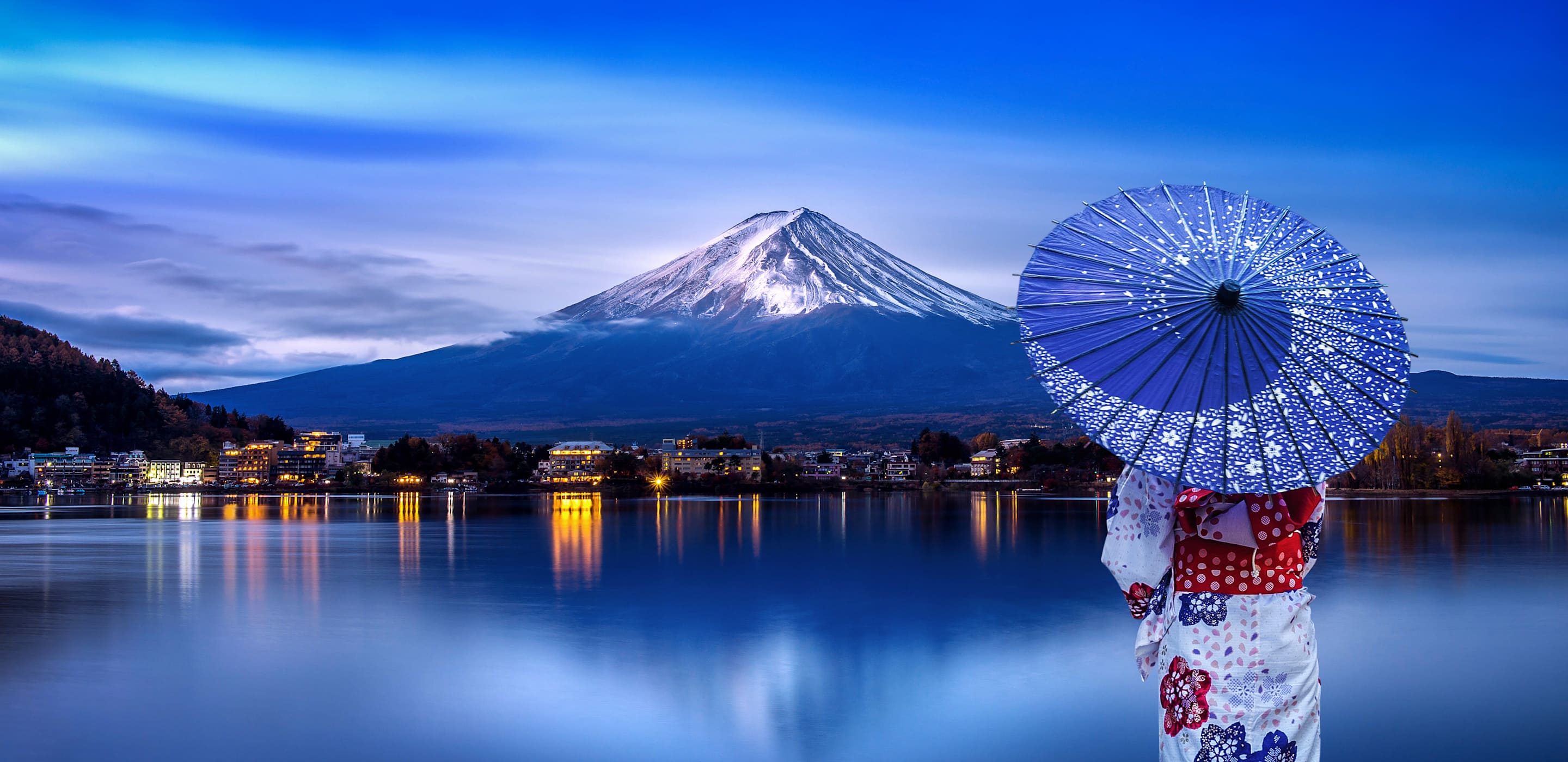 woman in geisha garb looking at mount fuji in japan