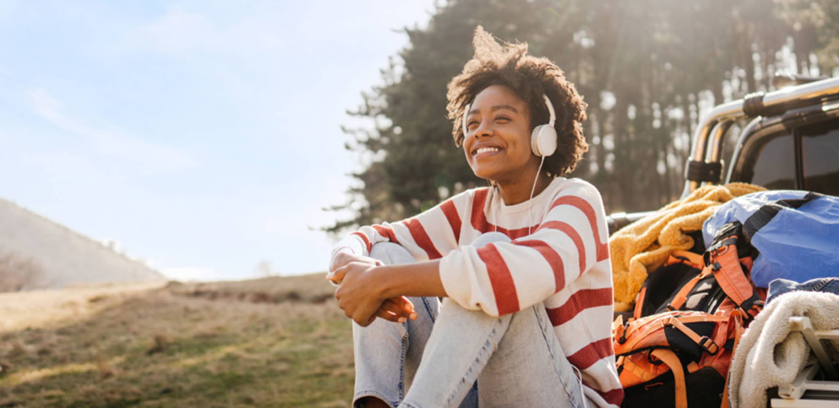 woman sitting on a truck bed listening to music