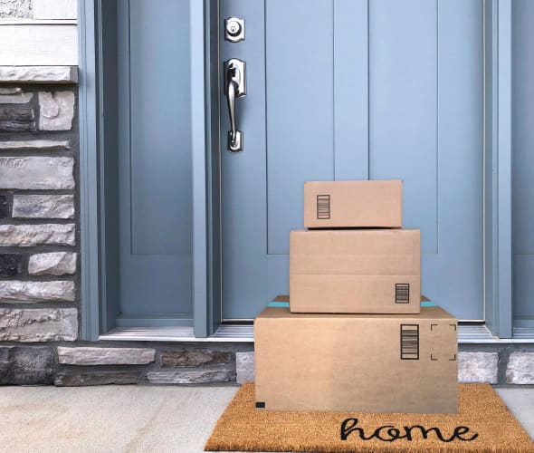 three packages stacked on mat at doorstep