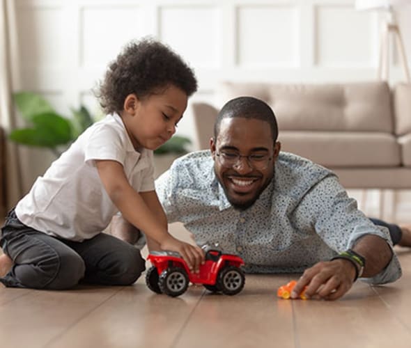 a AAA Member and his son play with a car on the floor