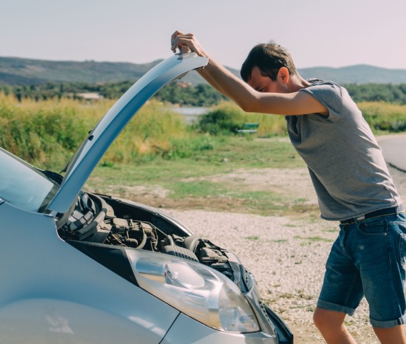 A AAA Member looks at a car battery