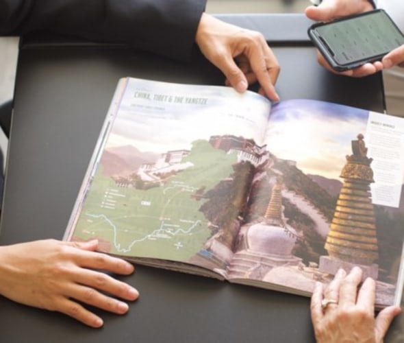 AAA Travel Agent shows a AAA vacation guide to China to a Member