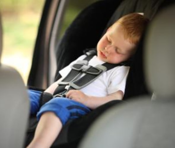 boy sleeps in booster car seat inspected by AAA technician
