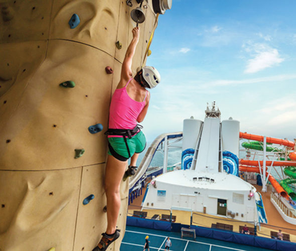 woman climbing rock wall on a royal caribbean cruise