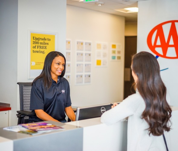 AAA member gets assistance from a AAA agent at a desk at a AAA office.