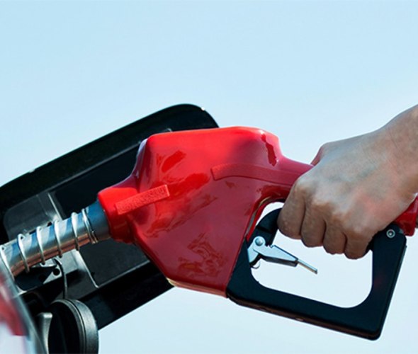 Close up of a hand pumping gas into a car