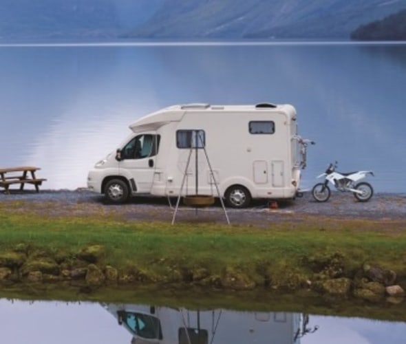 AAA Premier Members in their white RV by a lake