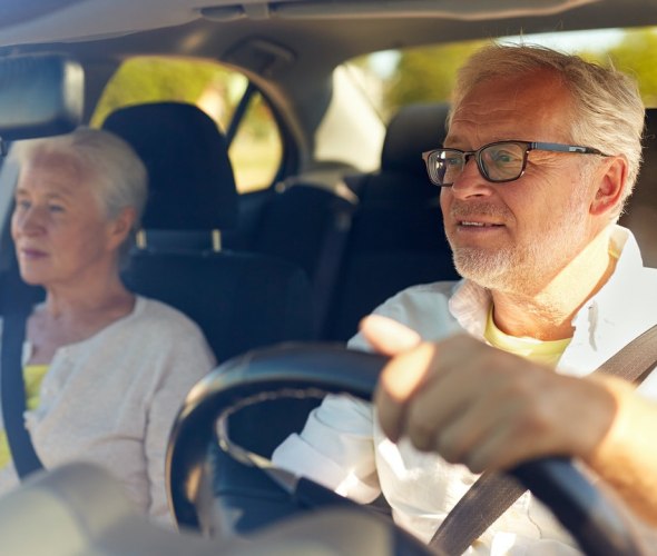 An elderly couple behind the wheel.