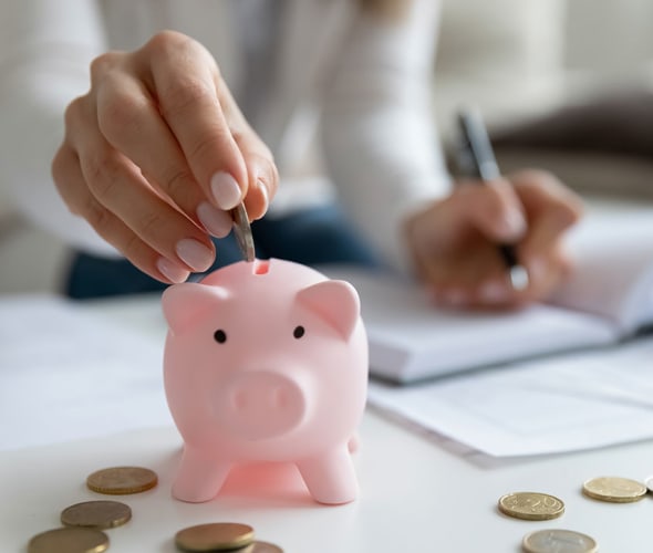A woman with AAA Auto Insurance puts her savings in a piggy bank