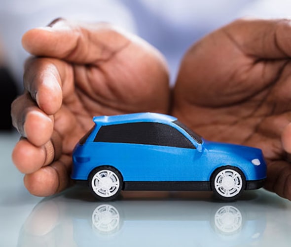 a pair of hands protect a blue toy car