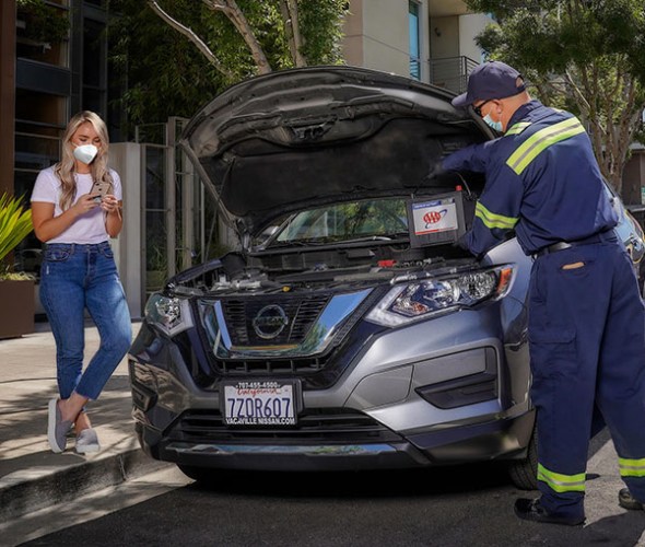 A Member of AAA has her battery replaced by a tow truck driver
