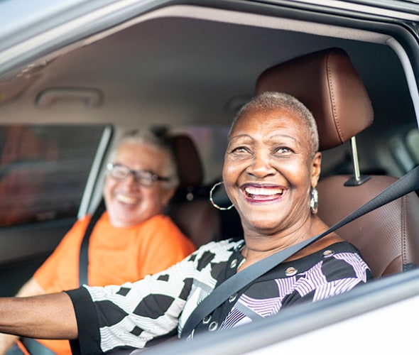 a retired AAA Member smiles from inside her car