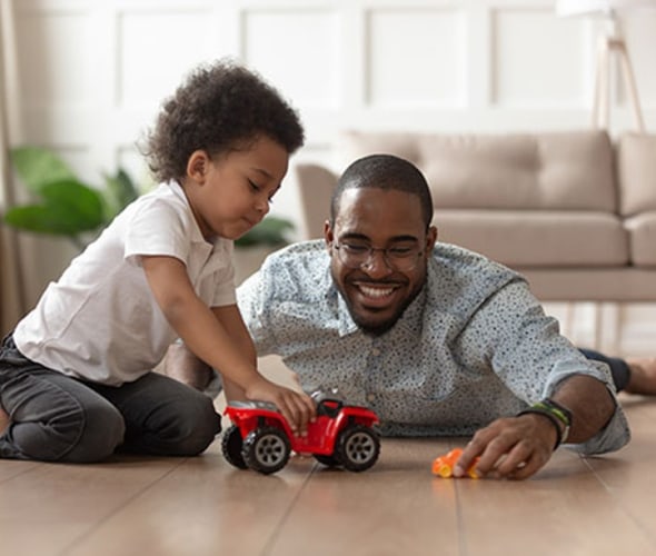 a AAA Member and his son play with a car on the floor