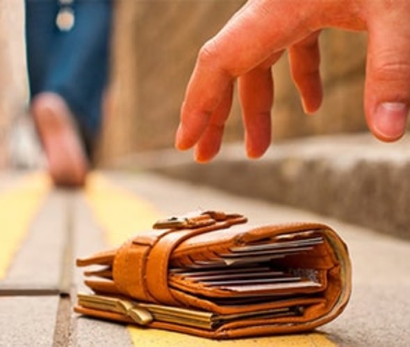 a person picks up a wallet from the ground