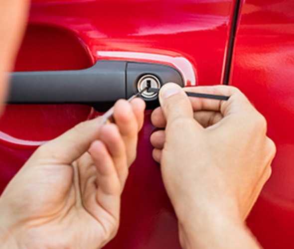 a AAA locksmith unlocks a red car door