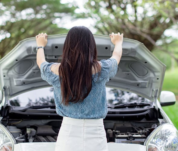 a AAA Member checks her car battery on the side of the road
