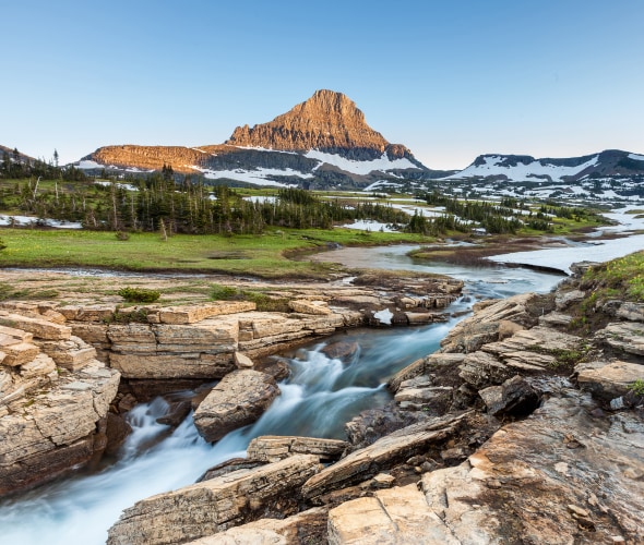 A stream cuts through Logan Pass in Montana's Glacier National Park in early summer.