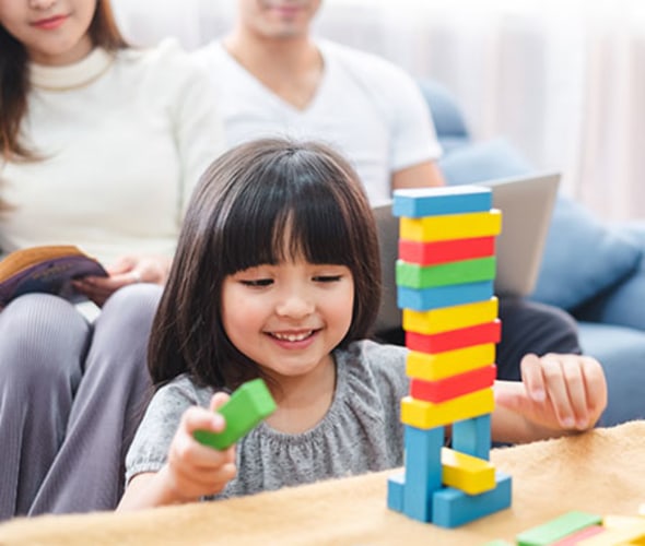 a girl plays with legos in her house insured with AAA 