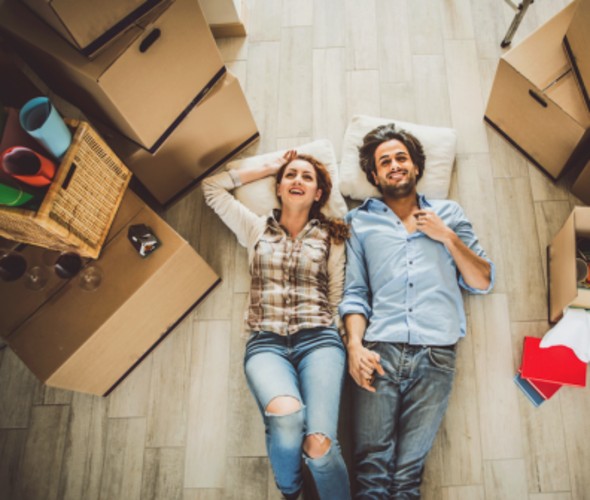 a couple with aaa membership rests on the floor of their new home after moving with aaa discounts