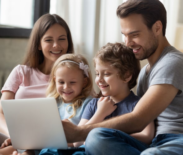 Family sitting on the couch with a laptop applying for AAA ExpressTerm life insurance 