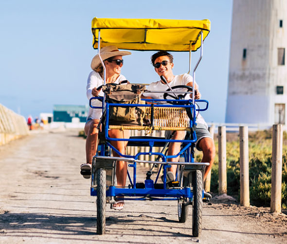 A AAA Universal Life Insurance customer and her son bike along a sunny beach