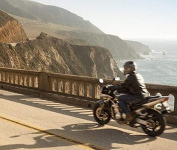 a motorcyclist with AAA specialty insurance drives down highway 1 in Big Sur on the California coast