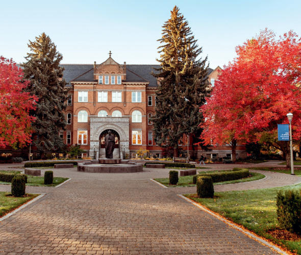 College Hall at Gonzaga University in Spokane, Washington surrounded by trees with red leaves.