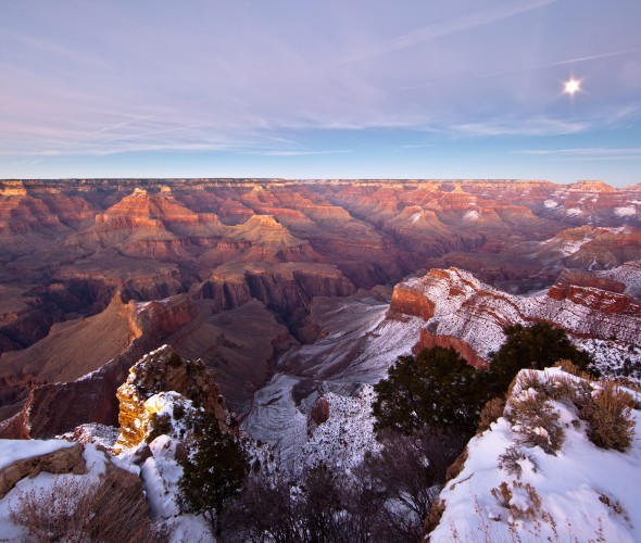 The Grand Canyon covered in snow at sunset.