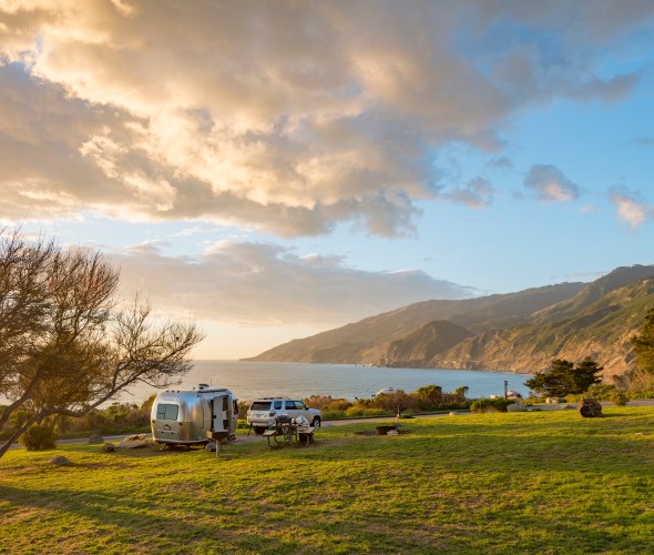 An airstream trailer parked at an ocean-side campsite at Kirk Creek Campground along Highway 1 in Big Sur, California.