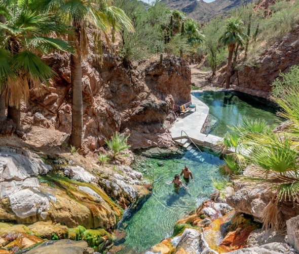 Two people soak in Castle Hot Springs in Morristown, Arizona.