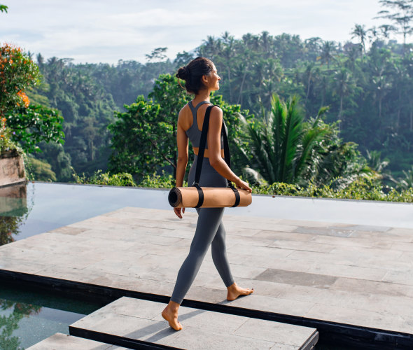 woman with yoga mat relaxing in bali