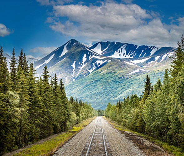 Train tracks toward mountain landscape 