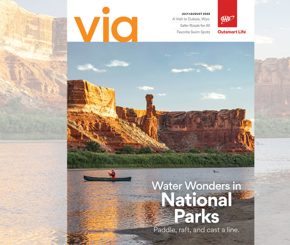 A person paddles up the green river at sunset on the cover of Via magazine July August 2022 issue.
