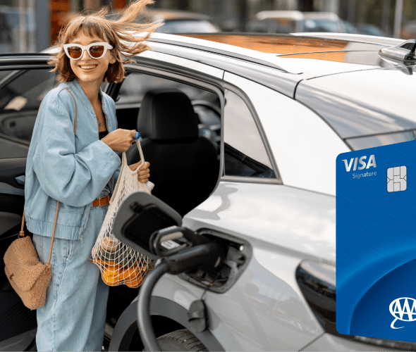 Woman putting groceries in back of electric car