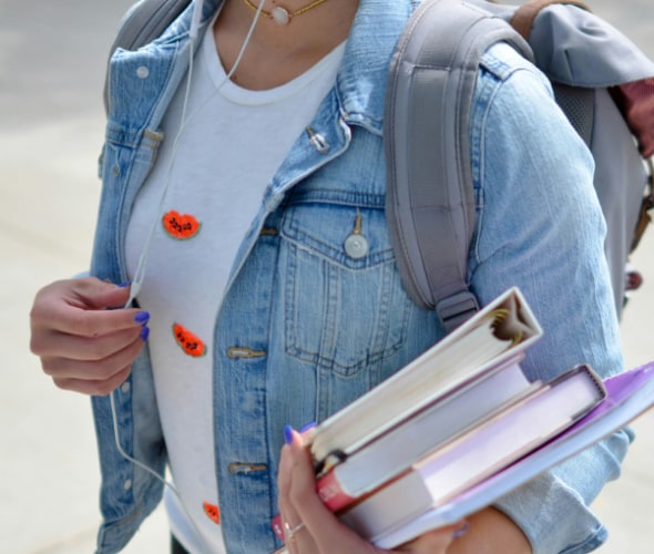 A college student with an armful of books protects themselves from identity theft scams