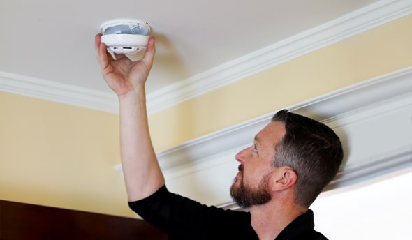 Man installing smoke alarm