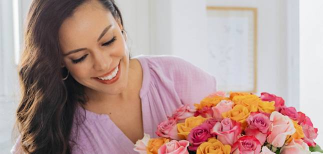 person smiling holding flowers 