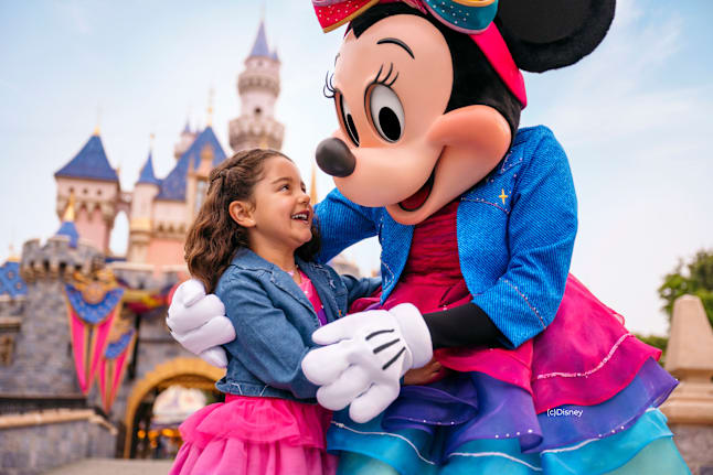minnie mouse in front of disneyland castle