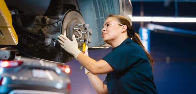 A car is up on a jack during a service at a AAA Auto Repair shop