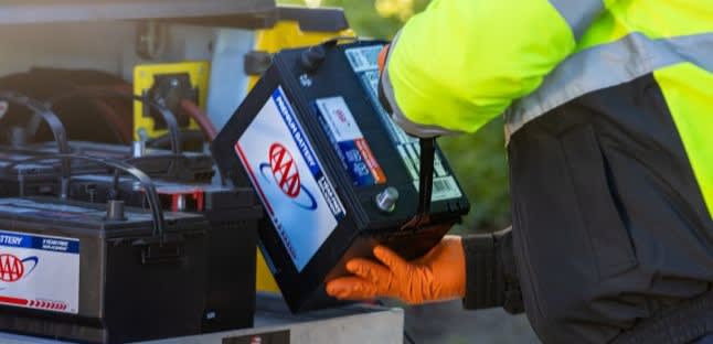 AAA technician pulls out a new AAA Battery during a mobile battery service