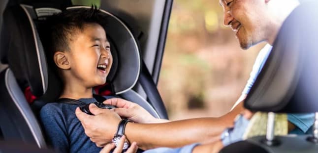 AAA car seat inspection representative shows a mother how to safely install a car seat in the carA h