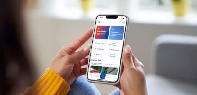 someone holds their phone while using the AAA Mobile App