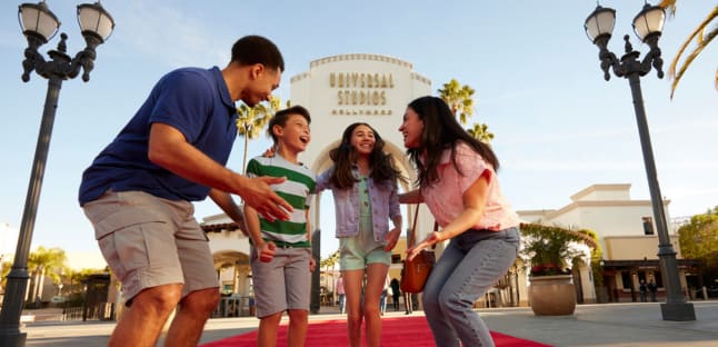 Family standing on red carpet in front of Universal Studios Hollywood entrance