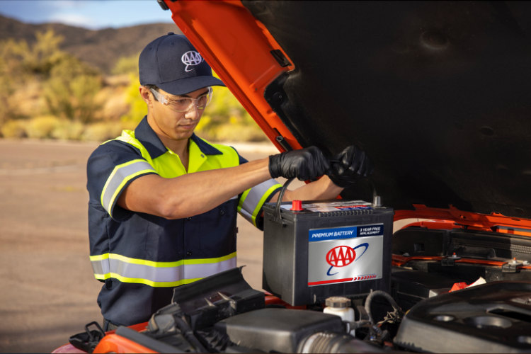A Member of AAA has her battery replaced by a tow truck driver