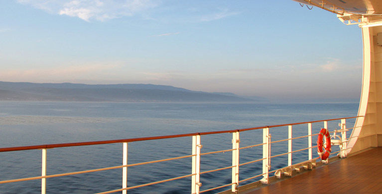 deck of cruise ship with coast in distance